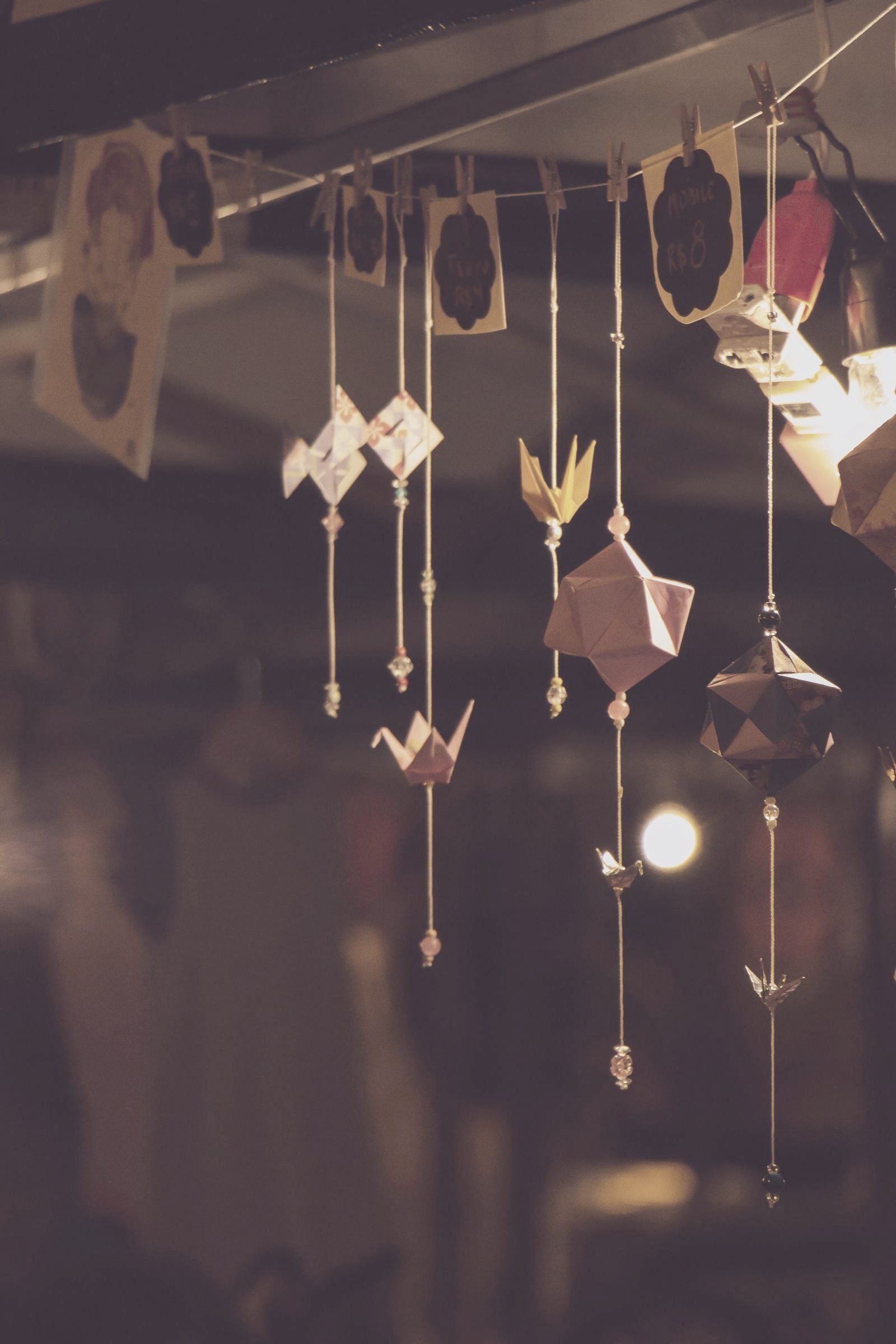 Paper cranes hanging at many heights, each folded from a single sheet.