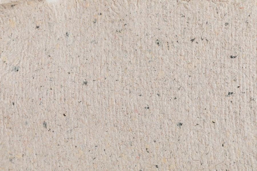Close detail of handmade paper, individual fibres visible across the surface.