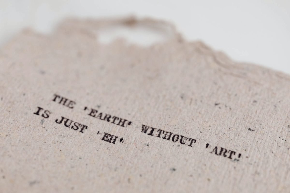 A single sheet of pale paper lying flat, its surface fibres catching a raking light.
