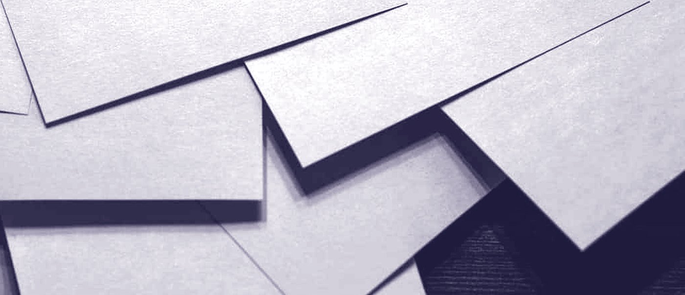 Pale cards of paper laid across a dark bench