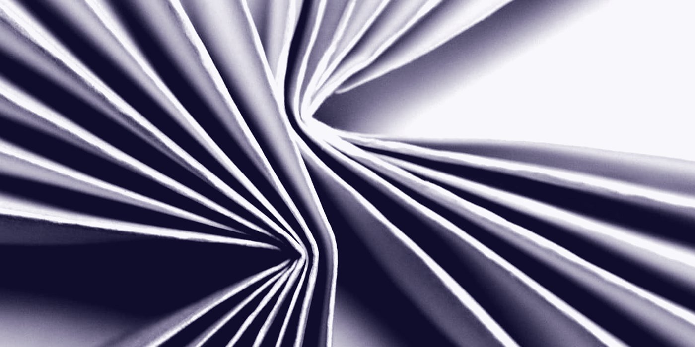 Folded paper, the light raking across the creases