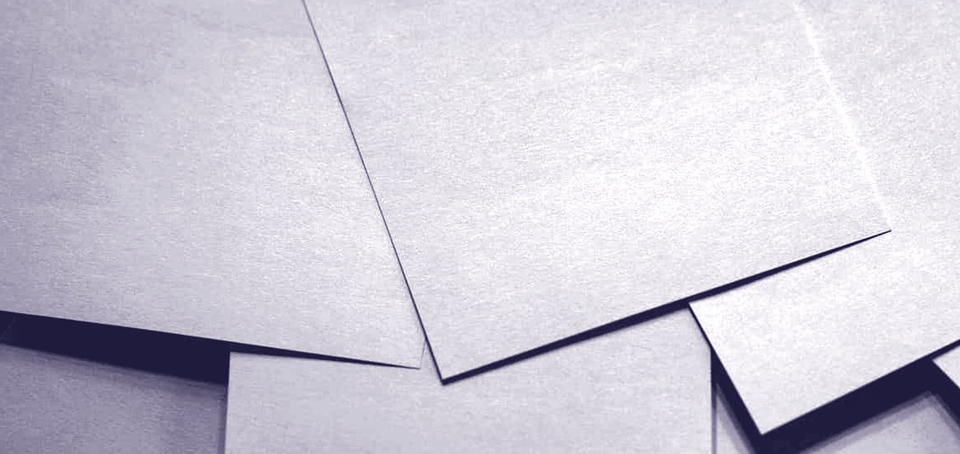 Folded paper, the light raking across the creases