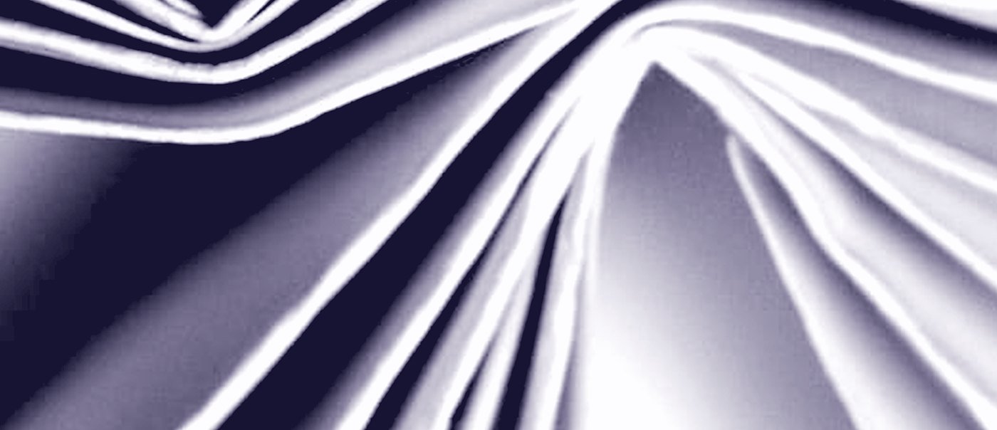Folded paper, the light raking across the creases
