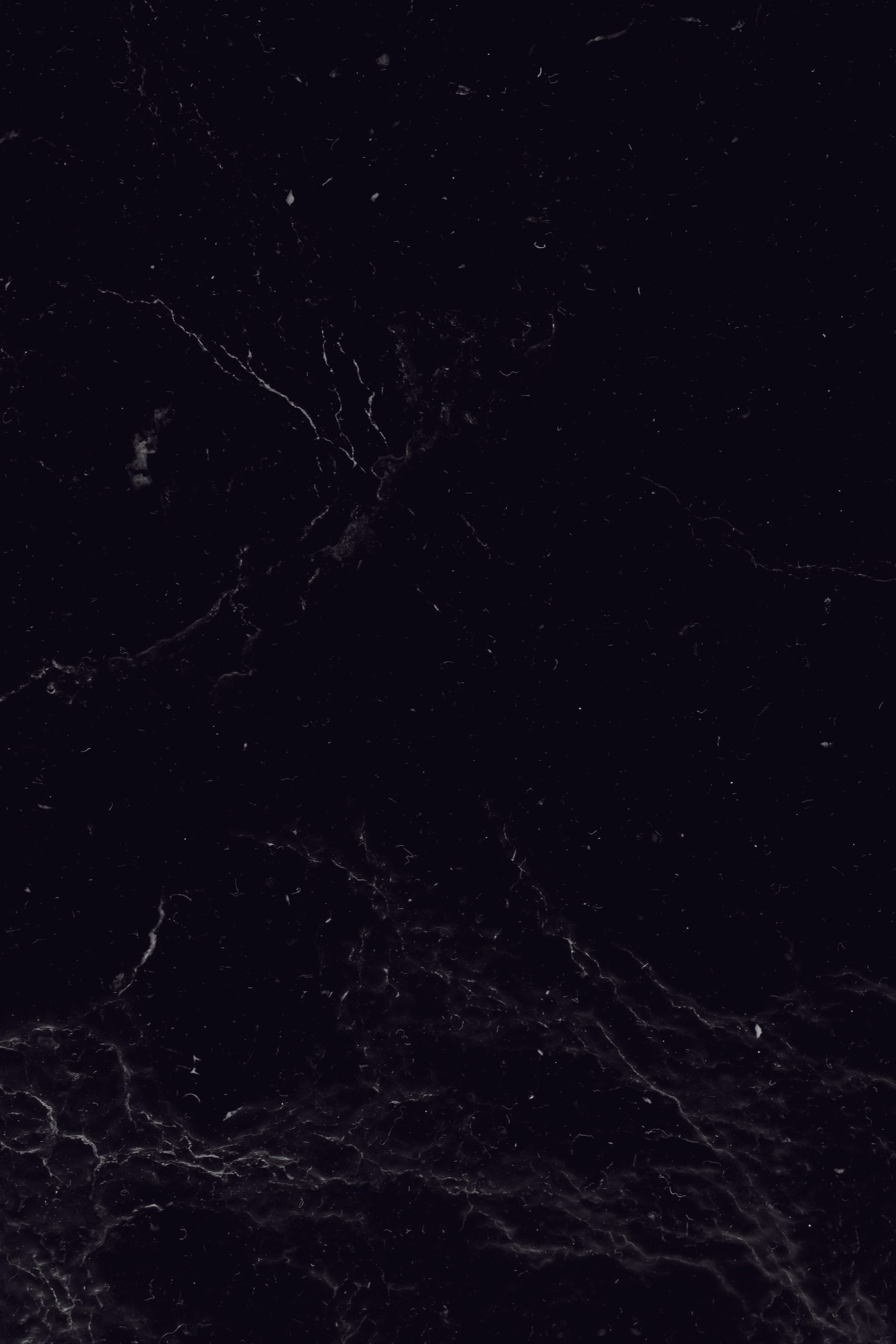 A dark slate surface with fine mineral veining running through the stone.