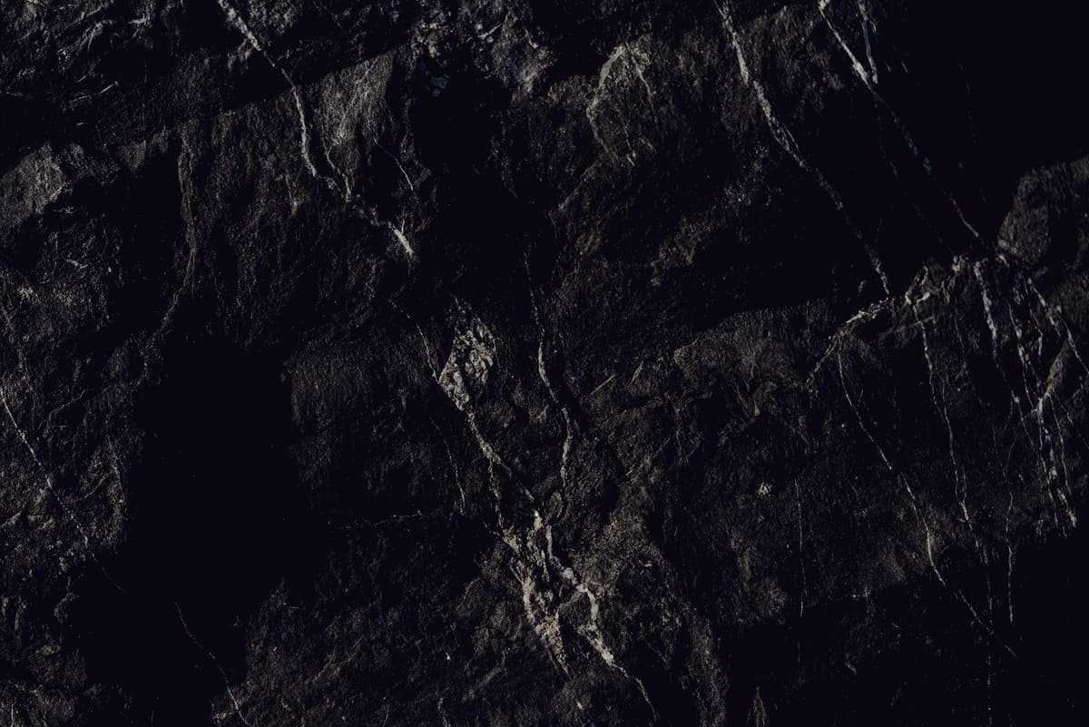 A dark slate face, one pale vein running through it