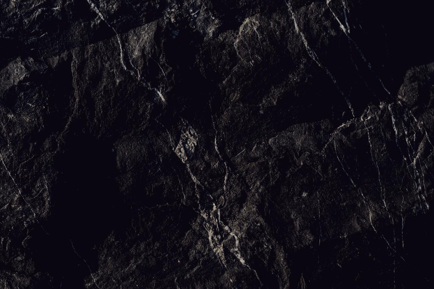 Close detail of dark slate, pale veins branching across the surface.