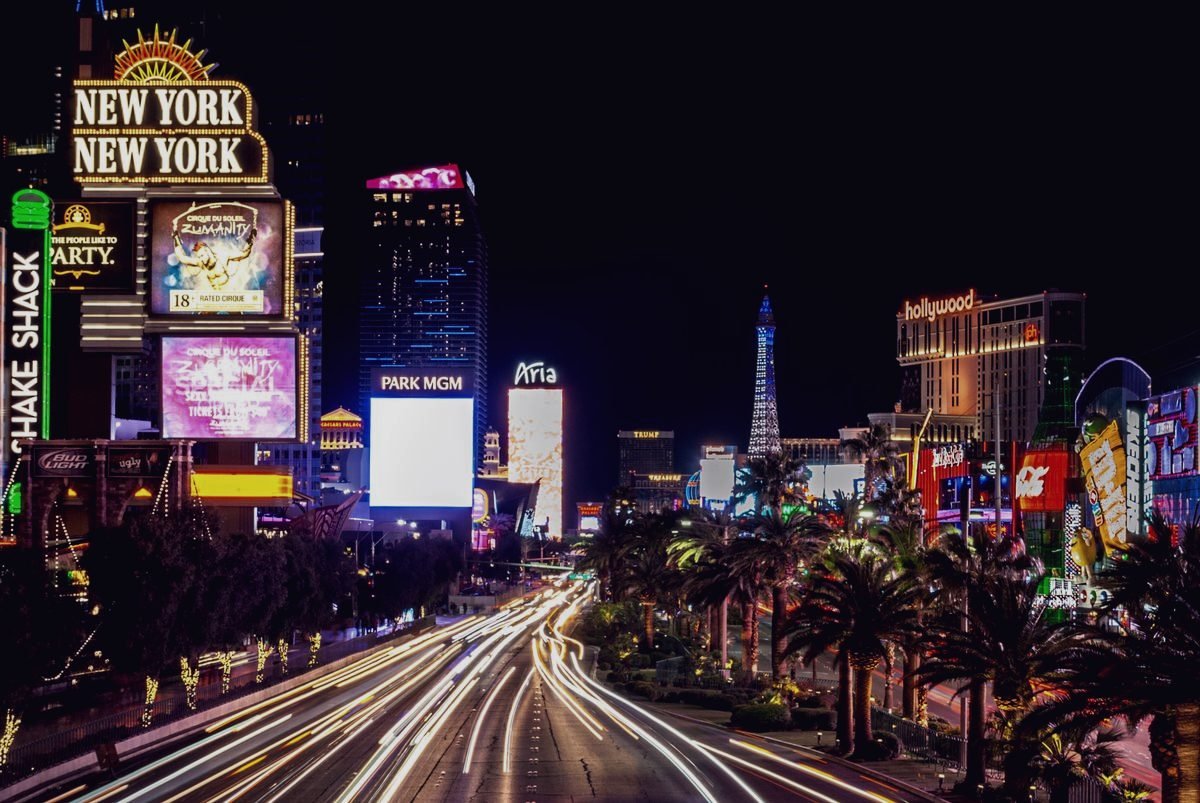 The Las Vegas Strip at night, headlights drawing long trails down the boulevard.